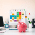 Birou de acasă cu calendar colorat din cuburi, pușculiță și pictograme cu mașină, casă, cadou și cruce medicală, simbolizând bugetarea și economisi...